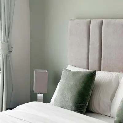 a bedroom with a white bed with a green pillow at Skyline Studio Apartment with Balcony in Dubai Marina in Dubai
