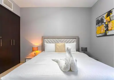 two white towels sitting on a bed in a bedroom at Stylish 2BR I Partial Burj View I Downtown Dubai in Dubai