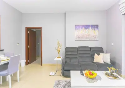 a living room with a couch and a table at Stylish 2BR I Partial Burj View I Downtown Dubai in Dubai