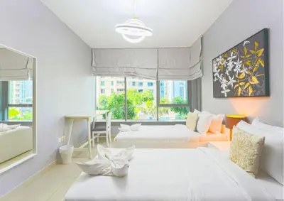 a bedroom with two beds and a table and a desk at Stylish 2BR I Partial Burj View I Downtown Dubai in Dubai