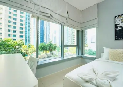 a bedroom with a white bed and a large window at Stylish 2BR I Partial Burj View I Downtown Dubai in Dubai