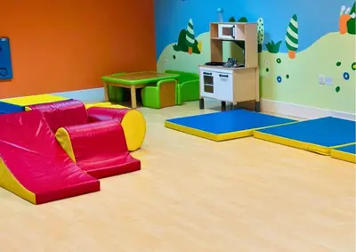a childrens play room with a red couch and a table at Stylish 2BR I Partial Burj View I Downtown Dubai in Dubai