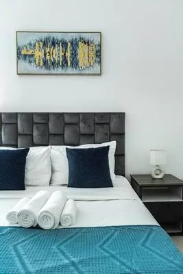 a bedroom with a bed with blue and white pillows at ShoresInn - Tranquil 1BR in Dubai Marina in Dubai