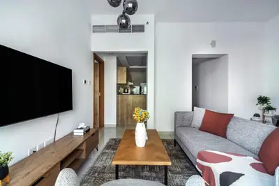 a living room with a couch and a tv at ShoresInn - Tranquil 1BR in Dubai Marina in Dubai
