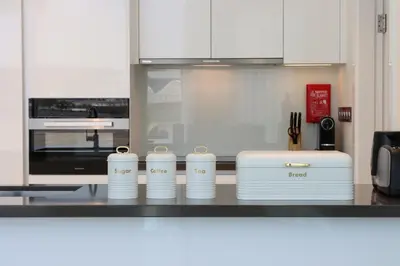 a kitchen counter with four stacks of white dishes at Lagoonview 2BR District One in Dubai