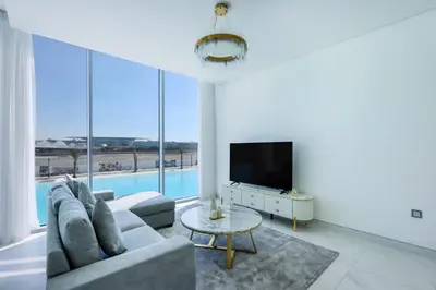 a living room with a couch and a tv at Lagoonview 2BR District One in Dubai