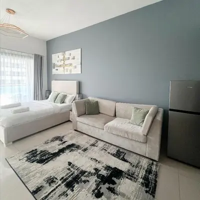 a living room with a couch and a bed at Studio Apartment with Stunning Marina Views in Dubai