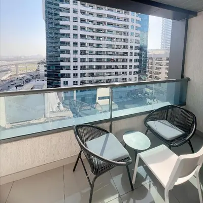 two chairs and a table on a balcony with a building at Studio Apartment with Stunning Marina Views in Dubai