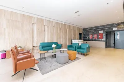a waiting area with chairs and tables in a lobby at Studio with Marina Breeze in Dubai
