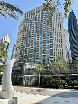 a large building with palm trees in front of it at Sophisticated Studio near Burj Khalifa in Dubai
