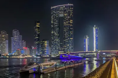 a boat docked at a dock in a city at night at Frank Porter - The Address JBR in Dubai