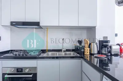 a kitchen with a sink and a stove at Bloomfileds Cozy Stu In Unistate Supreme Residence in Dubai