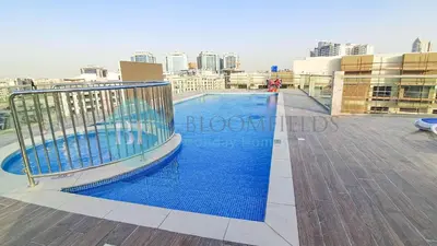 a swimming pool on the roof of a building at Bloomfileds Cozy Stu In Unistate Supreme Residence in Dubai
