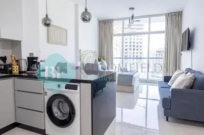 a kitchen and living room with a washing machine at Bloomfileds Cozy Stu In Unistate Supreme Residence in Dubai