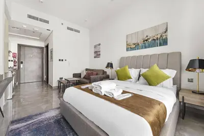 a bedroom with a large bed and a living room at Luxury Studio Apartments at Majestique Residence in Dubai