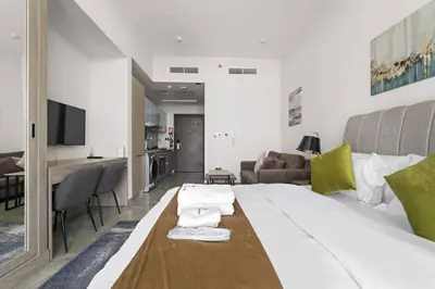 a bedroom with a large bed and a living room at Luxury Studio Apartments at Majestique Residence in Dubai