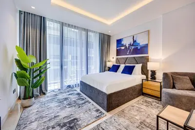 a hotel room with a bed and a couch at Cute studio in The Sterling by Omniyat in Dubai