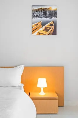 a bedroom with a bed with a lamp and a picture of boats at Spacious Studio With Dubailand Charm in Dubai