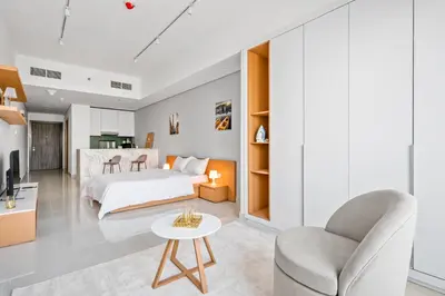 a bedroom with a bed and a chair at Spacious Studio With Dubailand Charm in Dubai