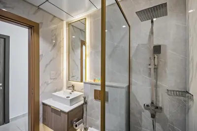 a bathroom with a sink and a shower at Bright Studio In Vibrant Dubailand District in Dubai