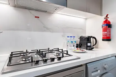 a kitchen with a stove top oven in a kitchen at Cozy 1BR with Pool View & Balcony in Dubai
