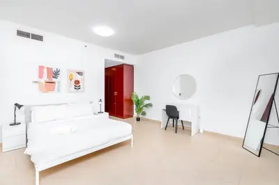 a white bedroom with a white bed and a desk at 1-BR Stunning Sea View Beachfront JBR in Dubai