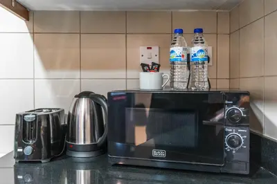 a microwave sitting on a kitchen counter with bottles of water at 1-BR Stunning Sea View Beachfront JBR in Dubai