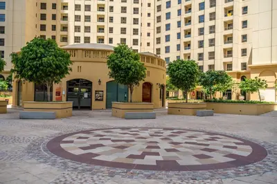 a large building with trees in the middle of a courtyard at 1-BR Stunning Sea View Beachfront JBR in Dubai