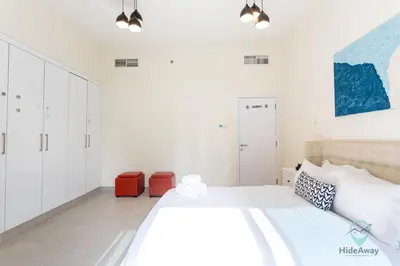 a white bedroom with a large bed and white cabinets at 2BR Stunning Luxury Heart of Marina Near Beach in Dubai