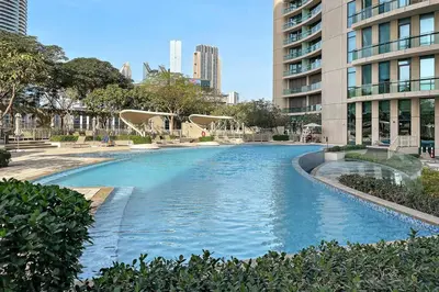 a large swimming pool in a city with buildings at Luxury 2BR Burj View with Pool Walk to Mall & Metro Dining Shopping in Dubai