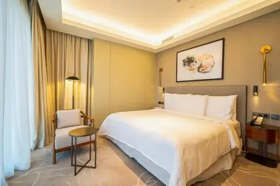 a hotel room with a large bed and a chair at NewArabian Opera Address Residences in Dubai