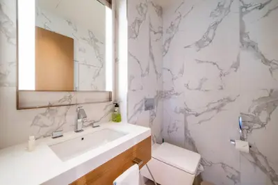 a white bathroom with a sink and a mirror at NewArabian Opera Address Residences in Dubai
