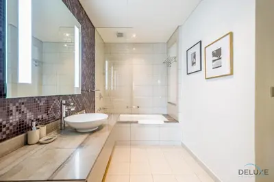 a bathroom with a sink and a tub and a toilet at Stylish 1BR in Damac Towers by Paramount B, Business Bay by Deluxe Holiday Homes in Dubai
