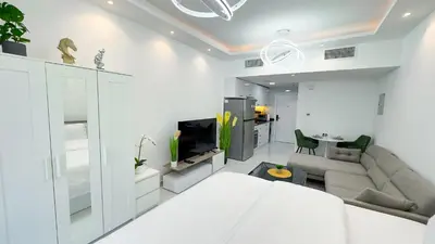 a white living room with a couch and a tv at Dubai Marina - Stylish Studio Apartment - Marina Diamond 2 in Dubai