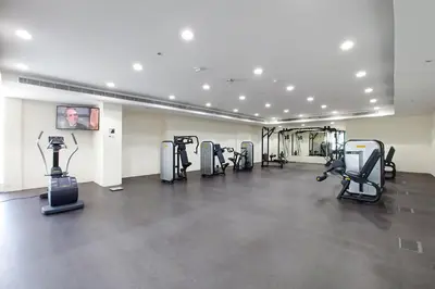 a gym with several treadmills and elliptical machines at Blueground Sheikh Zayed Rd pool gym DXB-462 in Dubai