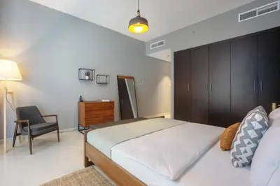 a bedroom with a large bed and a chair at Blueground Sheikh Zayed Rd pool gym DXB-462 in Dubai