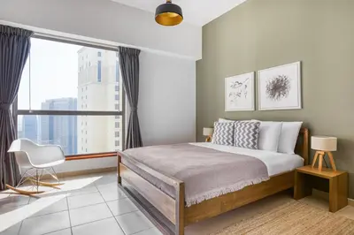 a bedroom with a bed and a large window at Blueground Sadaf sea view elevator gym DXB-925 in Dubai