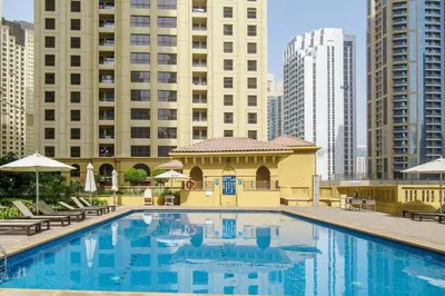 a large swimming pool in a city with tall buildings at Blueground Sadaf sea view elevator gym DXB-925 in Dubai