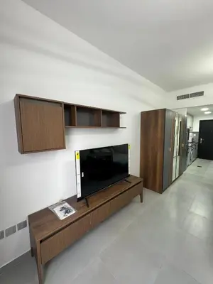 a living room with a flat screen tv on a wall at Jvc diamond 1 home in Dubai