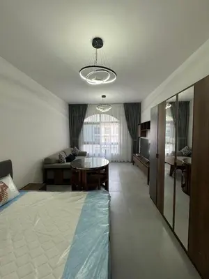 a room with a bed and a table and a couch at Jvc diamond 1 home in Dubai