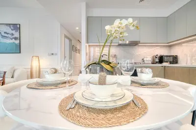 a white table with plates and glasses on it in a kitchen at Chic 2BR with Iconic Dubai Eye and Palm Views in Dubai