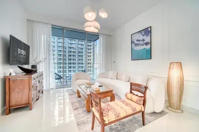 a living room with a white couch and a table at Chic 2BR with Iconic Dubai Eye and Palm Views in Dubai