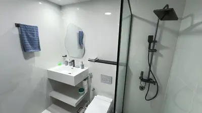 a white bathroom with a sink and a shower at Dubai Marina - 1 BHK Classy Apartment in Dubai