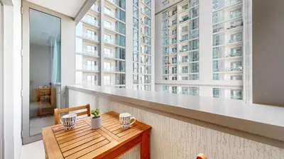 a balcony with a wooden table and a large window at Creek Vistas Reserve - Modern One Bedroom in Dubai