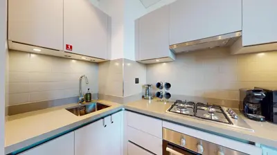 a kitchen with white cabinets and a sink at Creek Vistas Reserve - Modern One Bedroom in Dubai
