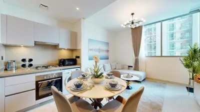 a kitchen and living room with a table and chairs at Creek Vistas Reserve - Modern One Bedroom in Dubai