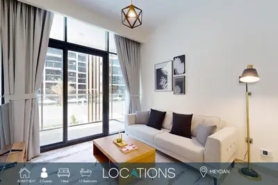 a living room with a couch and a large window at Azizi Riviera 18 - Neat One Bedroom in Meydan in Dubai