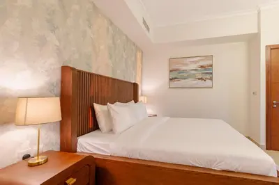 a bedroom with a bed and a table with a lamp at Dubai Mall Direct Connection Apartment - Burj Vista in Dubai