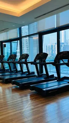 a row of pilates treadmills in a gym with windows at Dubai Mall Direct Connection Apartment - Burj Vista in Dubai