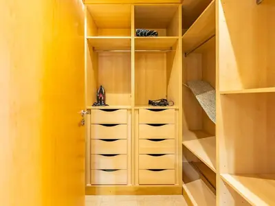 a walk in closet with yellow walls and wooden cabinets at Chic 4BR Apt Pool Palm Beach Club Dubai in Dubai